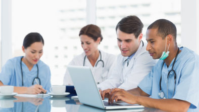 A group of doctors sit at a table, coming up with HIPAA compliant medical tech solutions.