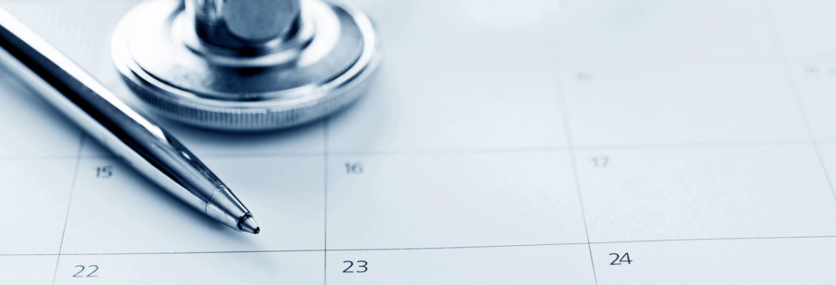 A stethoscope and a pen resting on a conventional paper calendar, to show how appointments were scheduled before online appointment booking.