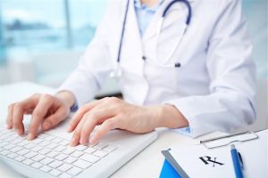 A doctor reviews their website on a laptop that is designed for practical usefulness.