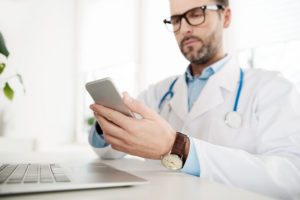 A doctor makes a post for his social media strategy and checks to assure that it doesn't violate any HIPPA regulations.